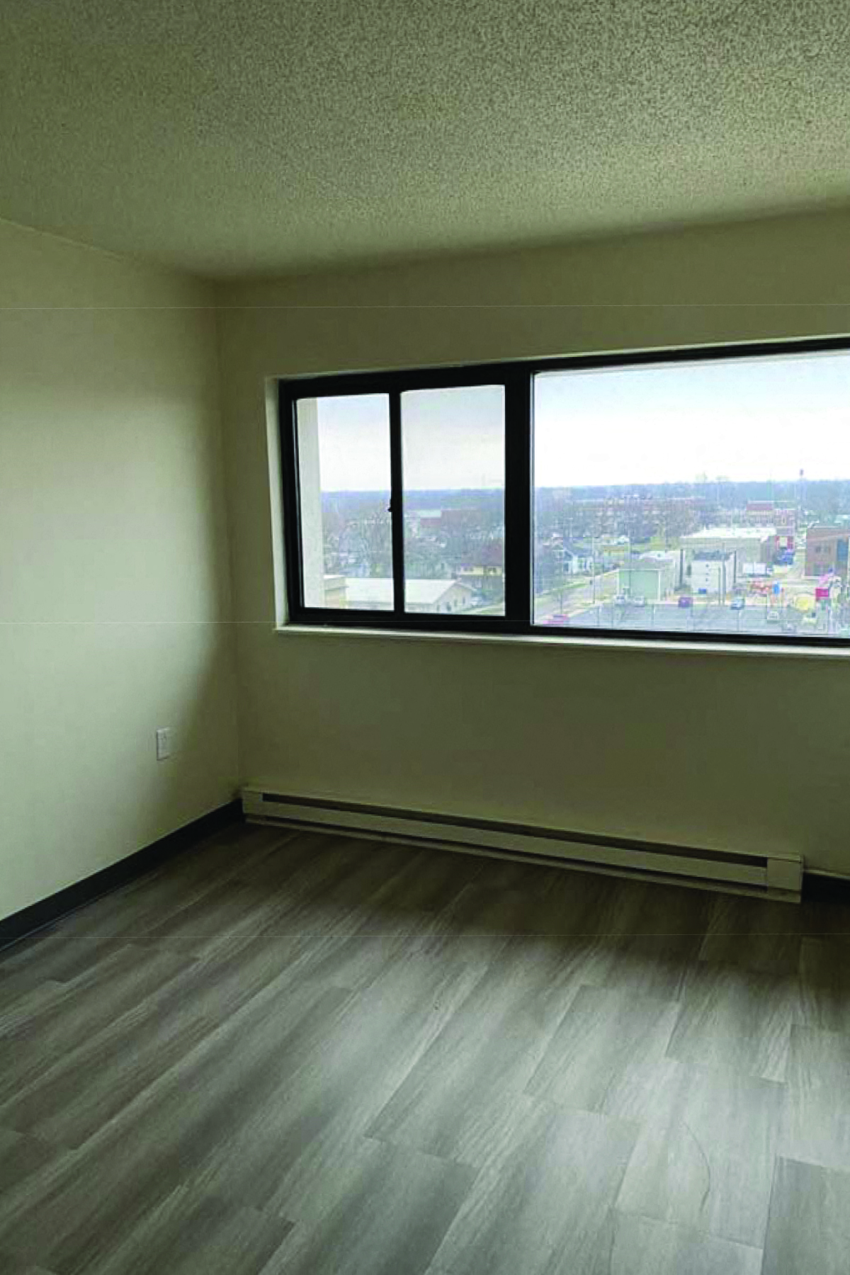 an empty room with three windows and a wooden floor